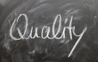 Reach excellence with quality the word written on a blackboard