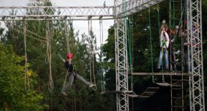 high-performing team participating in a high ropes course in the woods