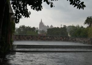 rain-a view from a courtyard with a church in the background