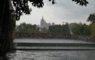 rain-a view from a courtyard with a church in the background