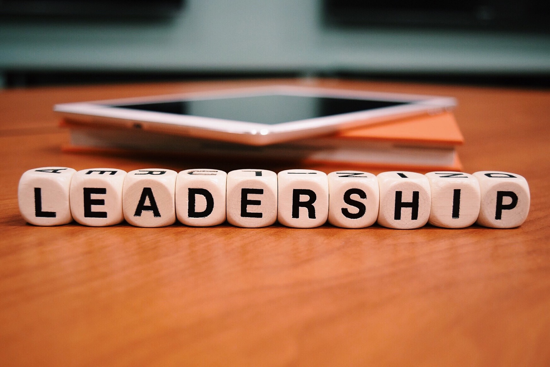 Great leaders-the word leadership spelled out with letter tiles on a table