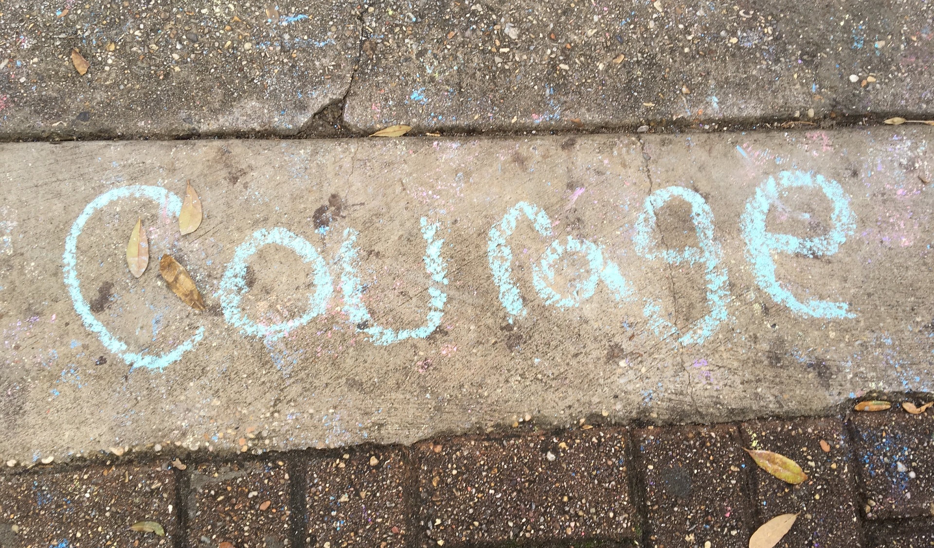 the word courage written in blue on a sidewalk-daring leadership