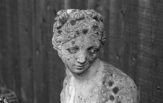 statue of a young woman with downcast eyes-lean into sorrow