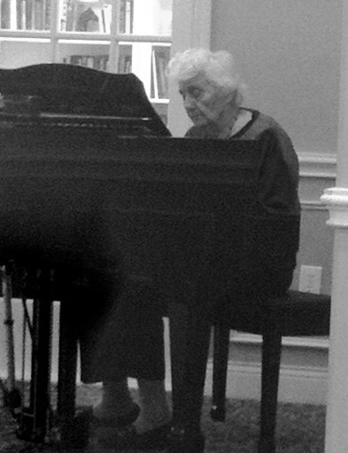 black and white photo of woman with Alzheimer's sitting at the piano -lost memories try to come back