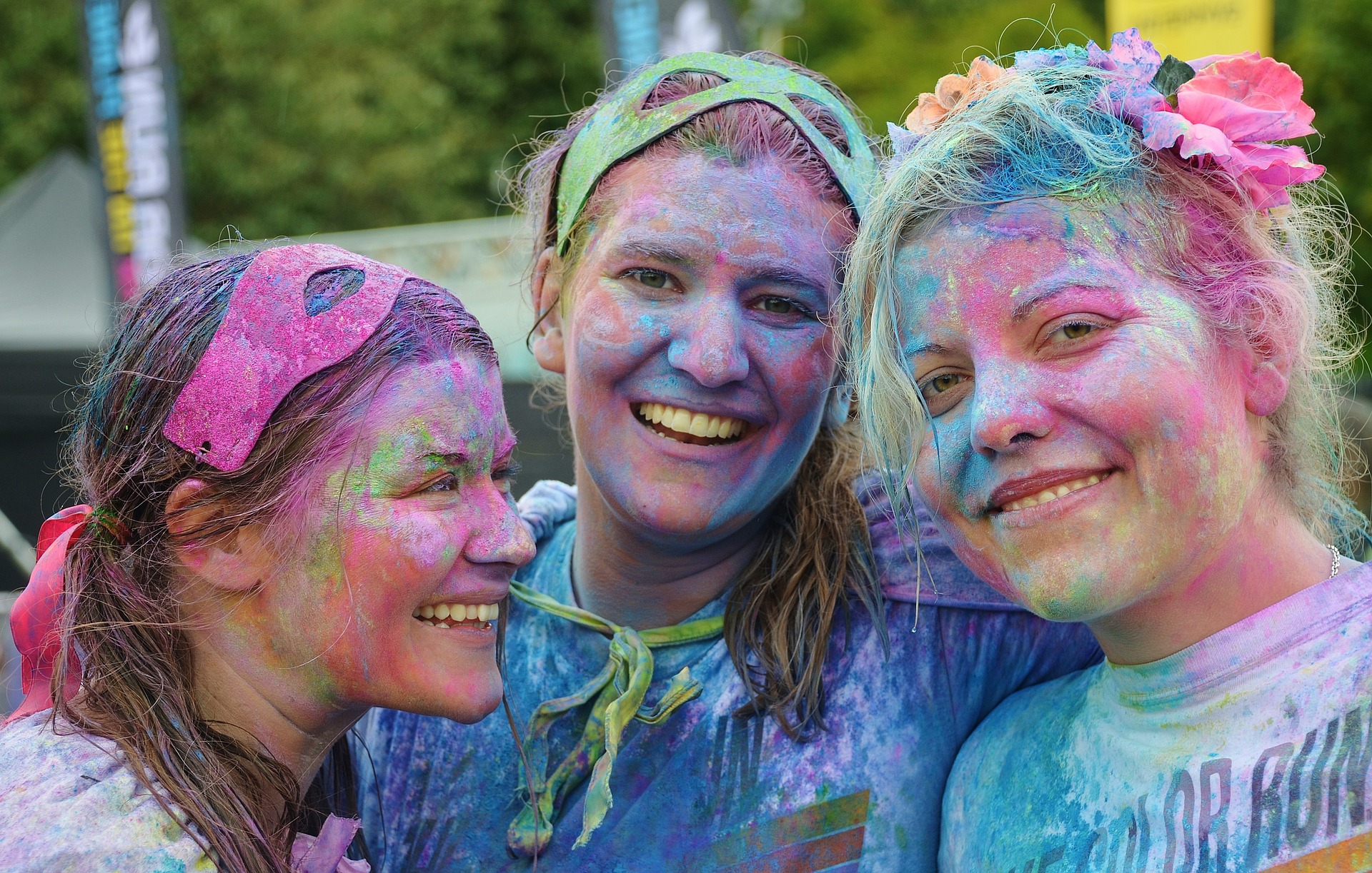 three girls with different colors of paint on their faces , in their hair, and on their clothes-humor